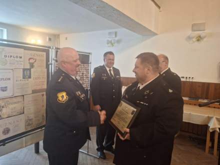 Przewodniczący Rady Miejskiej Czesław Greń oraz Naczelnik OSP Bąków Marcin Kajstura wręczają statuetkę św. Floriana i tabliczkę pamiątkową z życzeniami